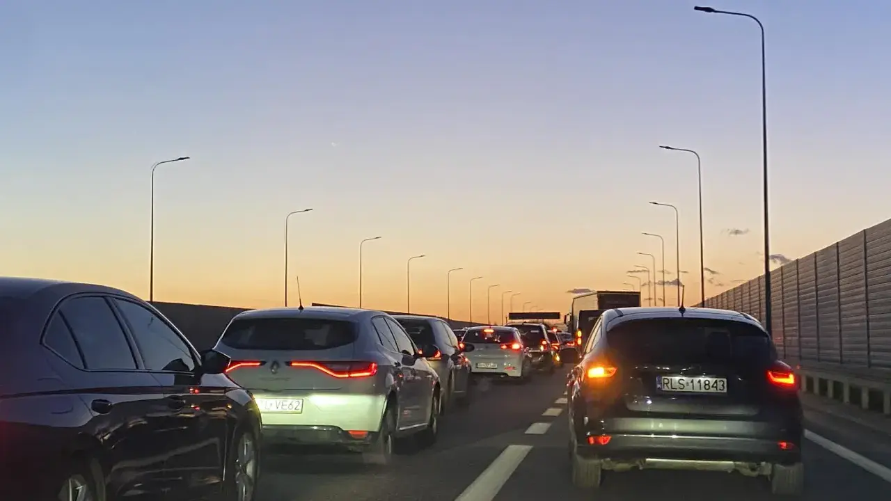 Korek na trasie Kraków - Poznań jak najszybciej. Samochody stoją na autostradzie o zachodzie słońca.