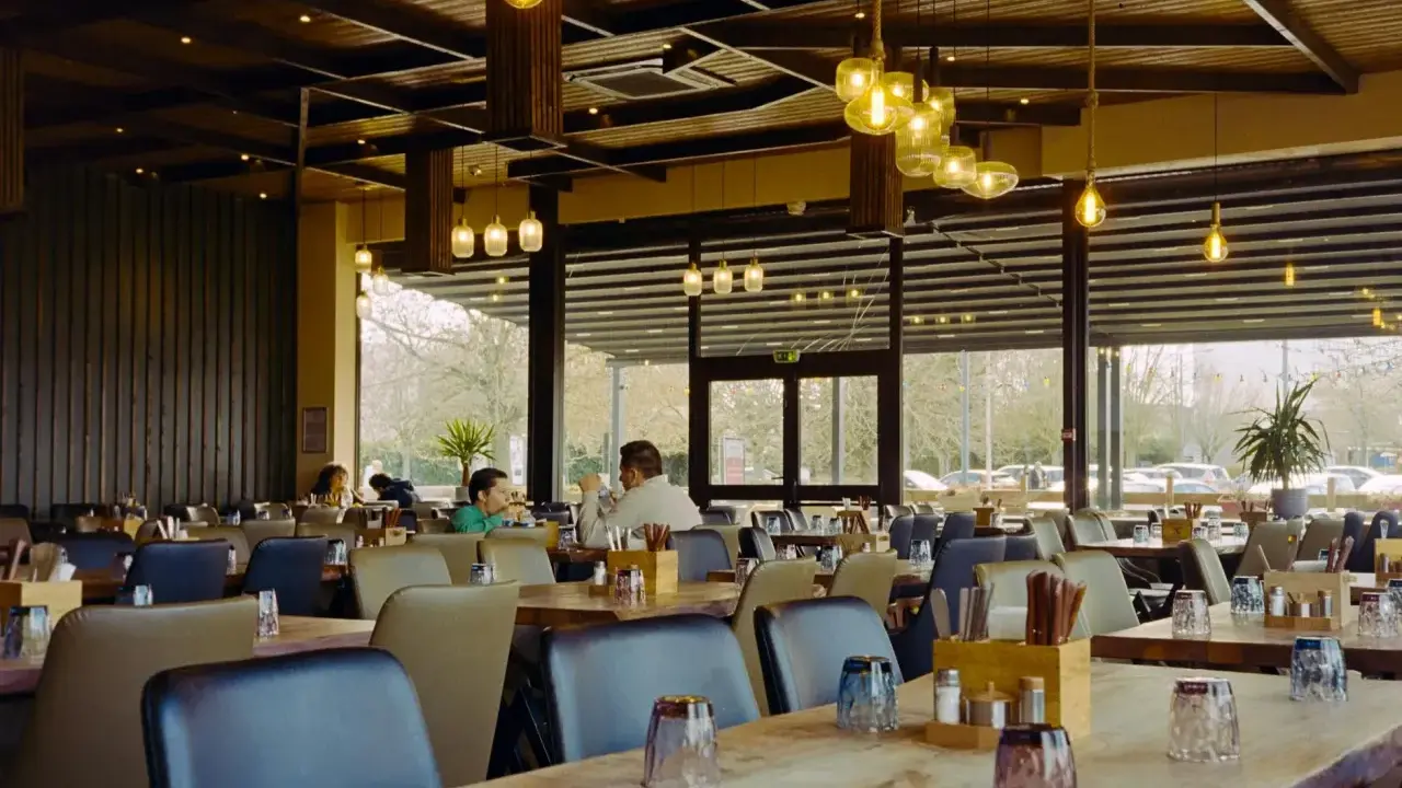 Przytulna restauracja z drewnianymi elementami i designerskimi lampami. Idealne miejsce na dobre jedzenie na trasie Kraków-Zakopane.