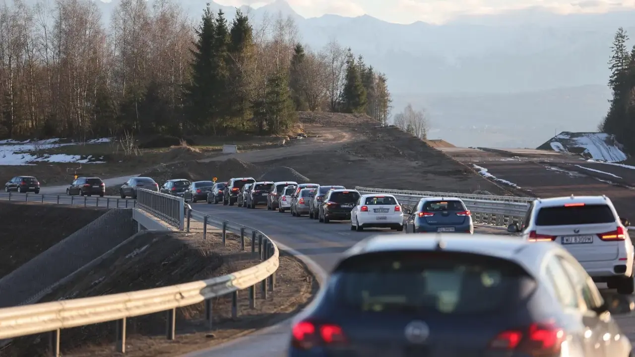 Korek na sieradz trasa. Samochody stoją w długiej kolejce na drodze z widokiem na góry i las.