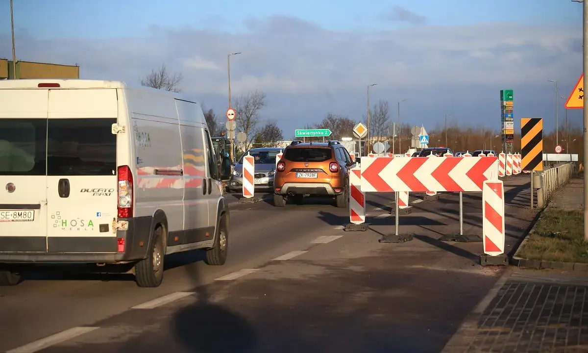 Korki na trasie do Władysławowa. Pomarańczowy SUV i biały bus stoją w kolejce za barierami drogowymi.