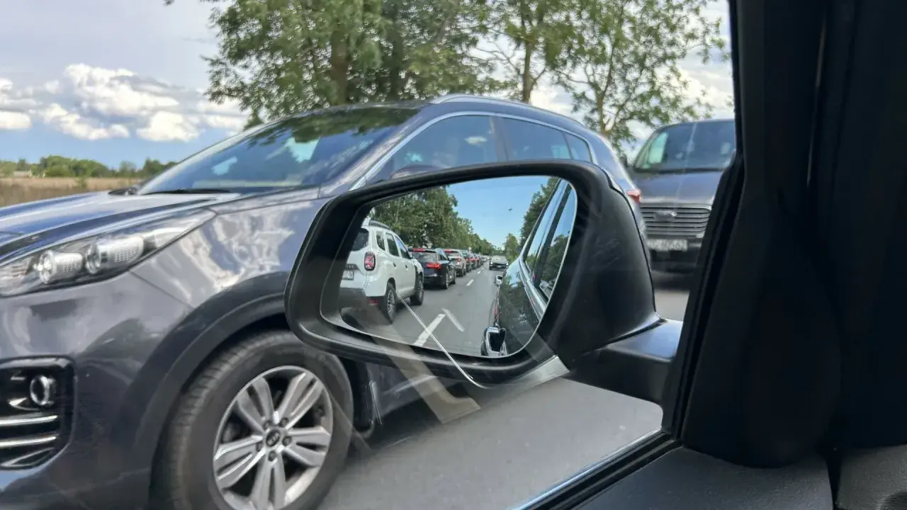 Korek na drodze do Mielna. W lusterku widać rząd samochodów, które utknęły w korku.