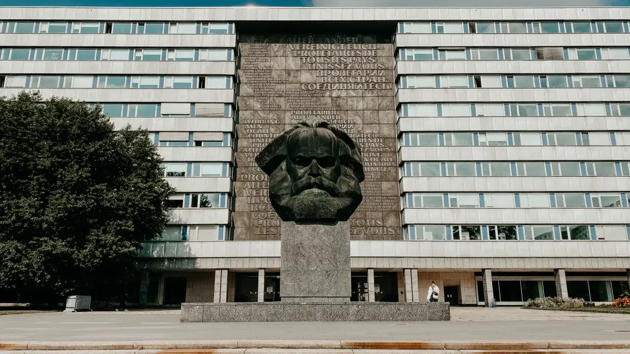 Pomnik Karola Marksa w Chemnitz, jedna z głównych atrakcji miasta, na tle modernistycznego budynku.