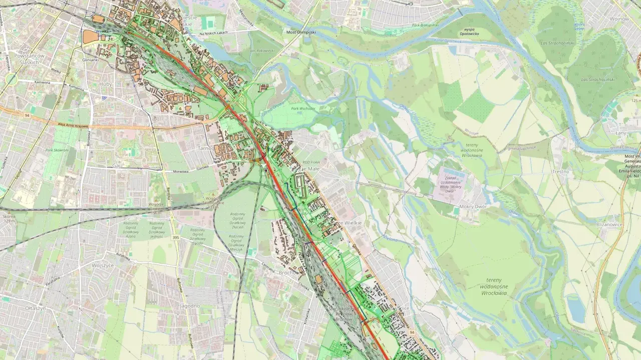 Mapa pokazuje fragment Wrocławia z zaznaczoną linią kolejową. Widać tereny zielone, rzekę Oławę i osiedla. Odległość między Koninem a Wrocławiem jest znacząca.