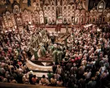 Uroczysta liturgia w największej cerkwi w Polsce. Wierni zgromadzeni wokół ikonostasu, duchowieństwo w bogatych szatach.