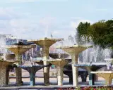 Wielopoziomowa fontanna w Gdyni, z wodą tryskającą na tle miasta. Trasa Gdynia tętni życiem obok tej wodnej atrakcji.