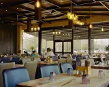 Przytulna restauracja z drewnianymi elementami i designerskimi lampami. Idealne miejsce na dobre jedzenie na trasie Kraków-Zakopane.
