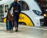 Podróż z Warszawy do Kołobrzegu pociągiem. Mężczyzna z walizką i plecakiem wchodzi do pociągu.