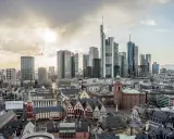 Widok na nowoczesne i zabytkowe frankfurt nad menem dzielnice, z drapaczami chmur i kościołami pod zachodzącym słońcem.