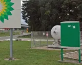 Stacja paliw z logo BP i dystrybutorem LPG. Widoczny zbiornik na gaz i znak "gpl" wskazujący kierunek. Ceny LPG w Europie mogą się różnić.