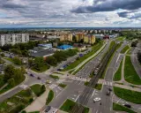 Widok z lotu ptaka na ruchliwe skrzyżowanie w Gdańsku Chełmie, z tramwajem, samochodami i budynkami mieszkalnymi w tle.