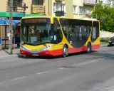 Żółto-czerwony autobus miejski z napisem "2 ENERGOMONTAŻ" na trasie w Sochaczewie.