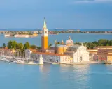 Wyspy laguny weneckiej: San Giorgio Maggiore z dzwonnicą i kościołem, otoczona wodą i łodziami.