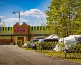 Zator Energylandia trasa: parking z samochodami i namiotami pod budynkiem "American Dream" w słoneczny dzień.