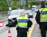 Policjanci kierują ruchem na trasie w Zgorzelcu. Jeden z nich trzyma znak "STOP".