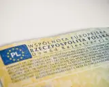 Dowód rejestracyjny pojazdu, niezbędny do ubezpieczenia auta, z flagą PL i tekstem w wielu językach.