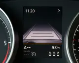 Wyświetlacz w samochodzie pokazuje widok drogi, zegar 11:20 i temperaturę 9°C. To pomocne informacje, gdy zastanawiasz się, tempomat co to jest i jak działa.