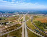Rozbudowa trasy gdańsk, widok z lotu ptaka na węzeł drogowy w otoczeniu pól i lasów.