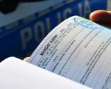 Dłoń trzyma mandat karny. Czy można uniknąć płacenia mandatu? Dokument zawiera rubryki do wypełnienia, np. odmowa przyjęcia.