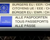 Znaki informacyjne na lotnisku: "Obywatele UE/EOG/CH" i "Wszystkie paszporty". Strefa Schengen-lista państw.