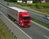 Czerwony tir Magtrans jedzie autostradą. Kierowca może otrzymać mandat za wyprzedzanie tirem w niewłaściwym miejscu.