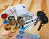 Kluczyki, pieniądze i figurka policjanta sugerują potencjalne mandaty w Niemczech.
