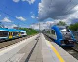 Dwa niebiesko-białe pociągi stoją na stacji, gotowe do podróży. Może to najszybsza trasa do Kielc?
