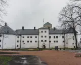 Biały zamek z wieżą i zielonym dachem, symbol najstarszego miasta w Finlandii.