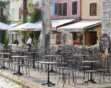 Letni dzień na półwyspie Istria. Pusta kawiarnia z czarnymi, metalowymi stolikami i krzesłami czeka na gości.