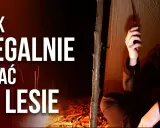 Jak legalnie spać w lesie? Młody mężczyzna w namiocie z radiotelefonem, obok ognisko.
