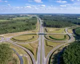 Węzeł drogowy na trasie Poznań-Kołobrzeg. Nowoczesna infrastruktura drogowa otoczona lasami i polami.