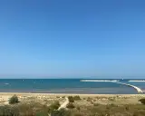 Piękny dzień nad morzem w Pescara i okolice. Wiele żaglówek na turkusowej wodzie, piaszczysta plaża i falochrony.