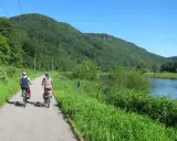 Dwie kobiety na rowerach przemierzają malownicze czeskie trasy rowerowe wzdłuż rzeki i zielonych wzgórz.