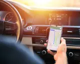 Kierowca używa nawigacji na telefonie. Zastanawia się, ile punktów karnych za telefon grozi za takie zachowanie.