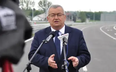 Mężczyzna w garniturze przemawia do mikrofonów na tle nowej drogi, która połączy Lublin i Rzeszów.