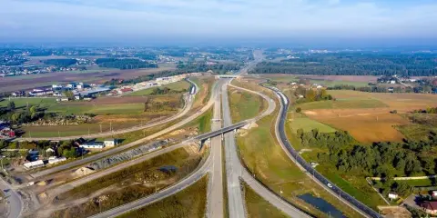 Rozbudowa trasy gdańsk, widok z lotu ptaka na węzeł drogowy w otoczeniu pól i lasów.
