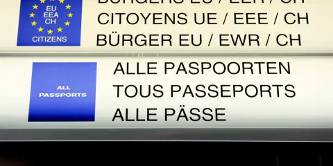Znaki informacyjne na lotnisku: "Obywatele UE/EOG/CH" i "Wszystkie paszporty". Strefa Schengen-lista państw.