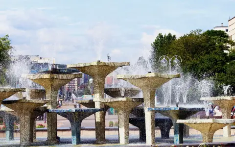 Wielopoziomowa fontanna w Gdyni, z wodą tryskającą na tle miasta. Trasa Gdynia tętni życiem obok tej wodnej atrakcji.