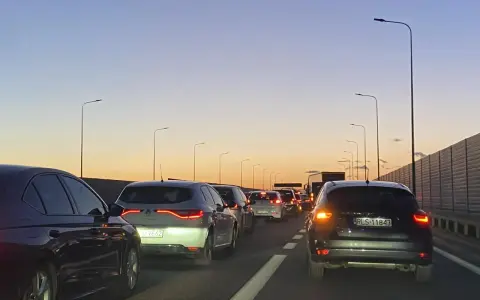 Korek na trasie Kraków - Poznań jak najszybciej. Samochody stoją na autostradzie o zachodzie słońca.