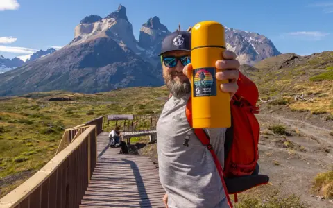 Mężczyzna z żółtym termosem na tle majestatycznych gór. To z pewnością Patagonia, a nie Alzacja.