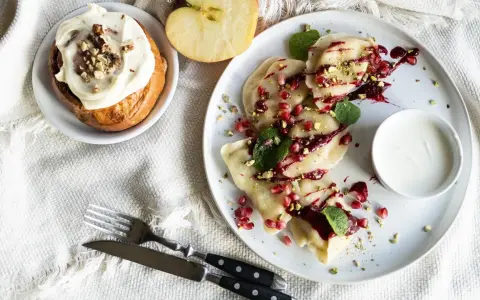 Pyszne pierogi z granatem i pistacjami, słodka bułka z kremem i jabłko. Idealne dobre jedzenie na trasie Warszawa-Lublin.
