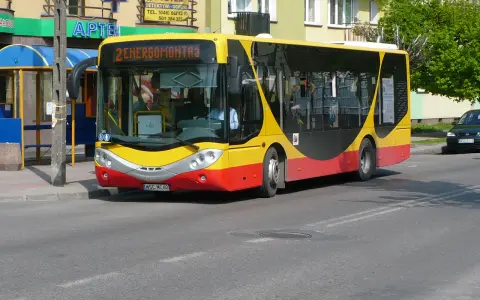 Żółto-czerwony autobus miejski z napisem "2 ENERGOMONTAŻ" na trasie w Sochaczewie.
