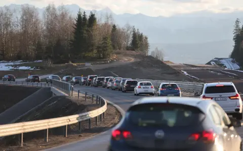 Korek na sieradz trasa. Samochody stoją w długiej kolejce na drodze z widokiem na góry i las.