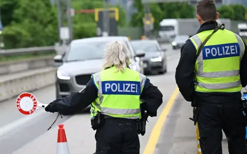 Policjanci kierują ruchem na trasie w Zgorzelcu. Jeden z nich trzyma znak "STOP".