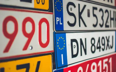 Stos tablic rejestracyjnych państw UE, w tym PL, SK, DN.