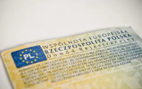 Dowód rejestracyjny pojazdu, niezbędny do ubezpieczenia auta, z flagą PL i tekstem w wielu językach.