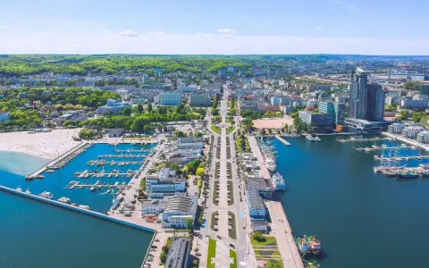 Widok na Gdynię z lotu ptaka. Widać port jachtowy, plażę i zabudowę miejską. Odległość do Wejherowa jest spora, ale widok zapiera dech.