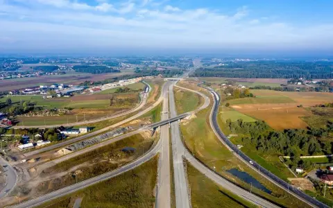 Rozbudowa trasy gdańsk, widok z lotu ptaka na węzeł drogowy w otoczeniu pól i lasów.