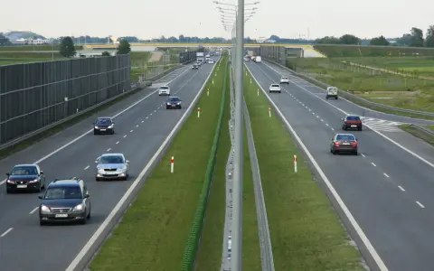 Różne rodzaje dróg: autostrada z pasami ruchu, barierkami i ekranami akustycznymi. Samochody poruszają się po jezdni.