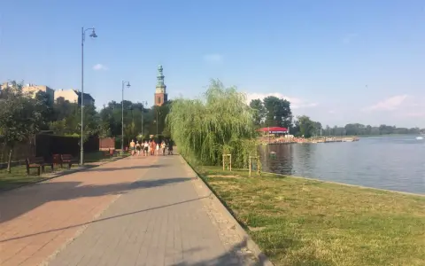 Spacer po chełmno trasa nad jeziorem. W oddali widać wieżę kościelną i zabudowania.