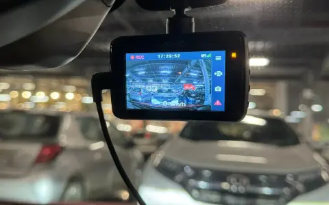 Wideorejestrator Mio nagrywa parking w Czechach. Widok z kamery samochodowej na rząd aut.